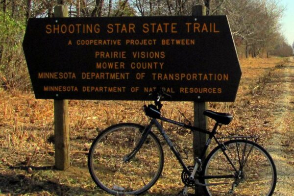 Bicycle leaning against sign promoting the Shooting Star Trail