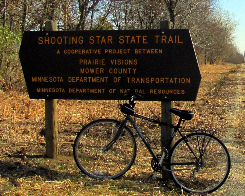 Bicycle leaning against sign promoting the Shooting Star Trail